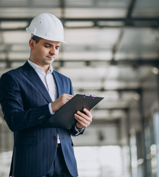 Handsome business man engineer in hard hat in a building